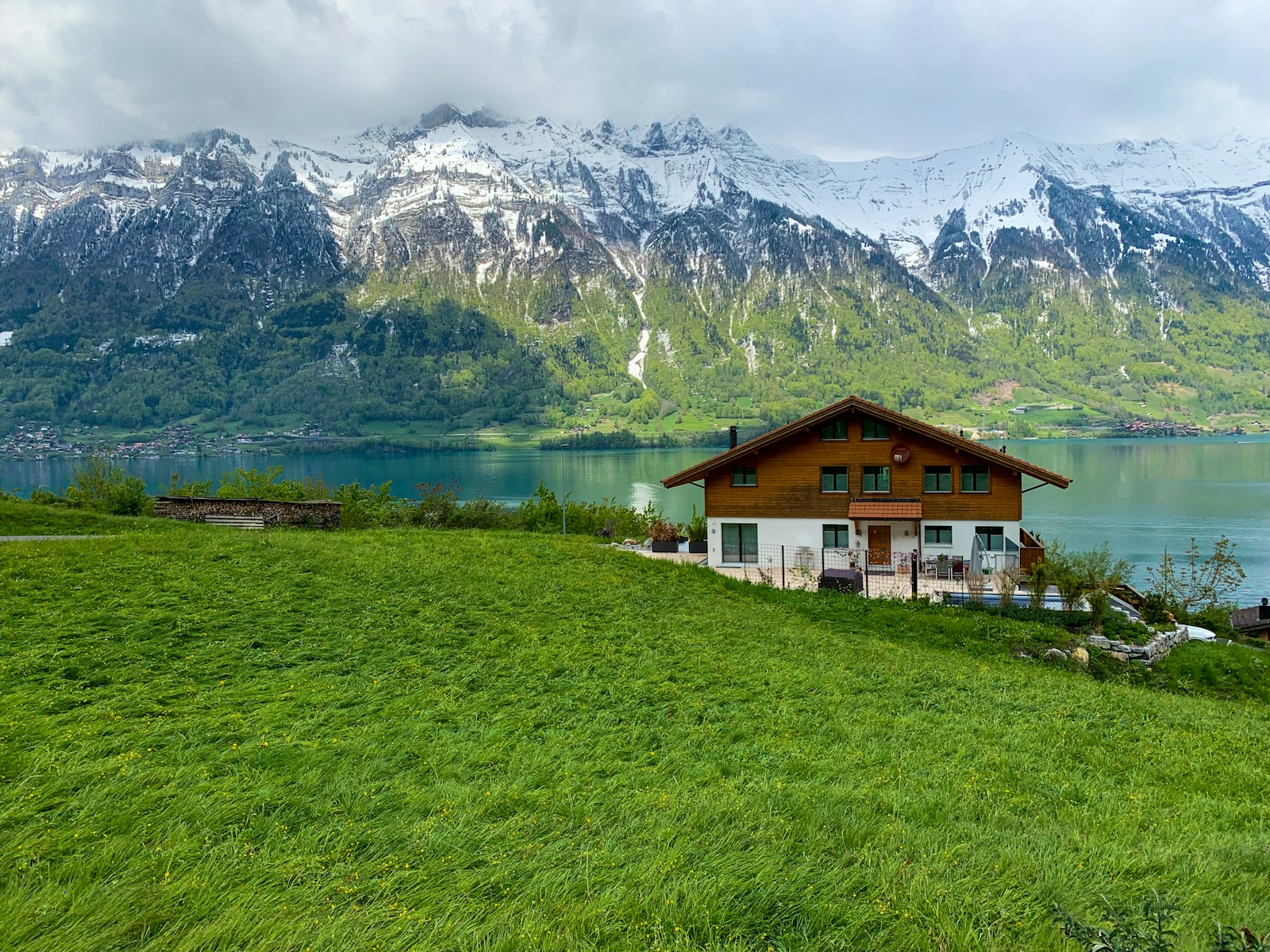 Chalet au bord d'un lac, montagnes en arrière-plan