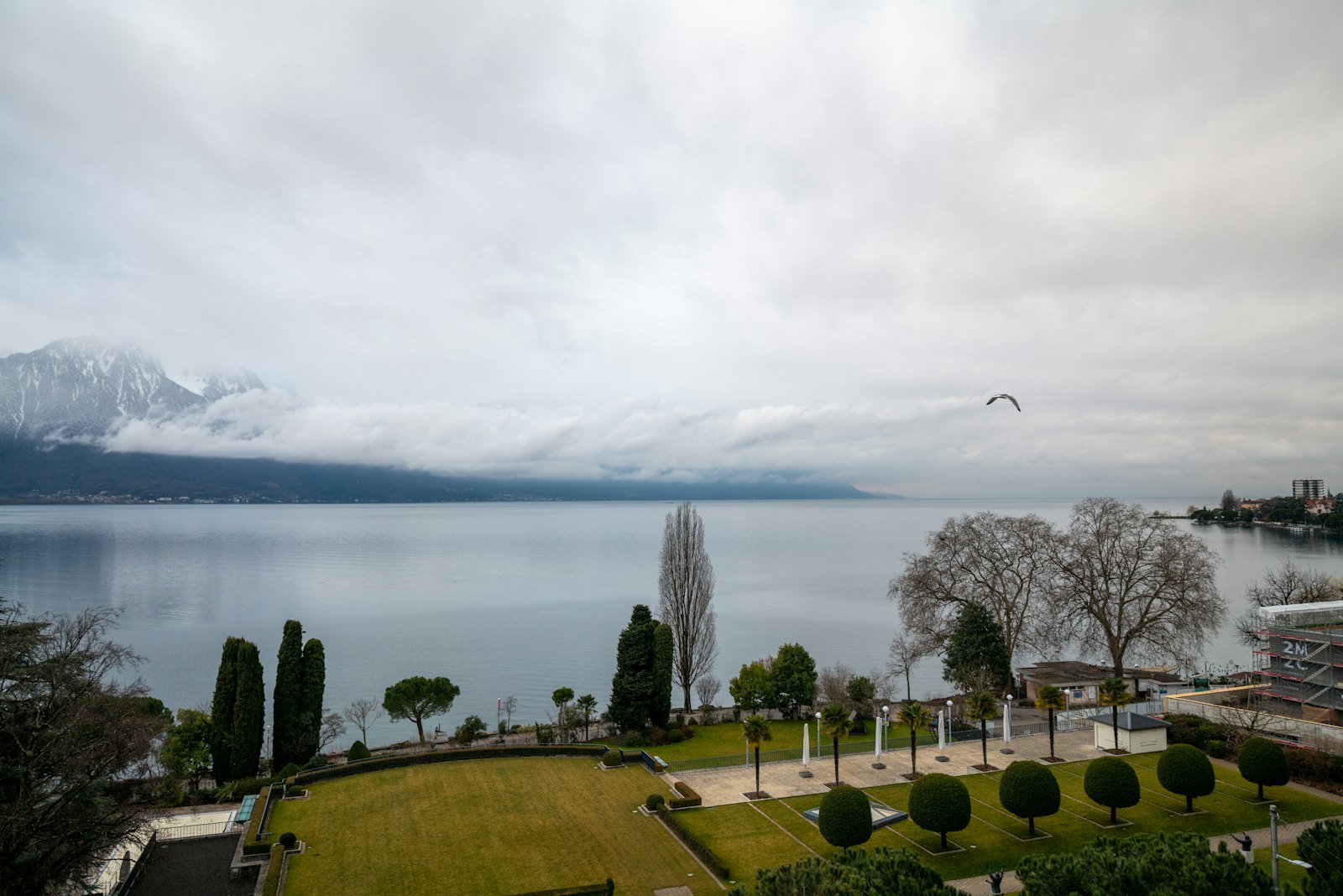Jardin au bord du lac Léman, montagnes dans les nuages