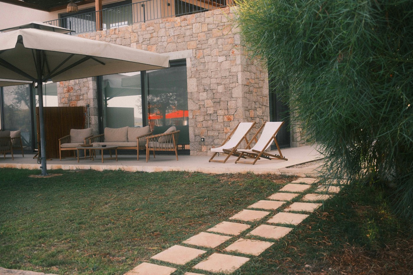 Terrasse en pierre avec deux chaises longues